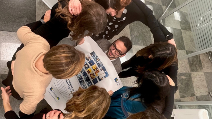 Foto di Paolo Berdini: persone in cerchio con al centro giornale